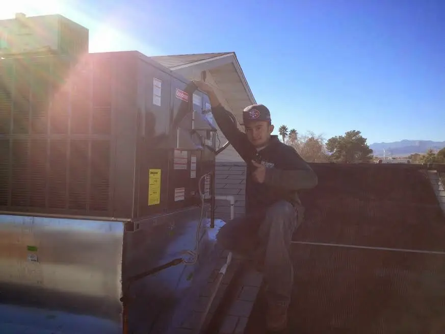 HVAC technician performing AC Tune-Up on a rooftop unit in Gurnee